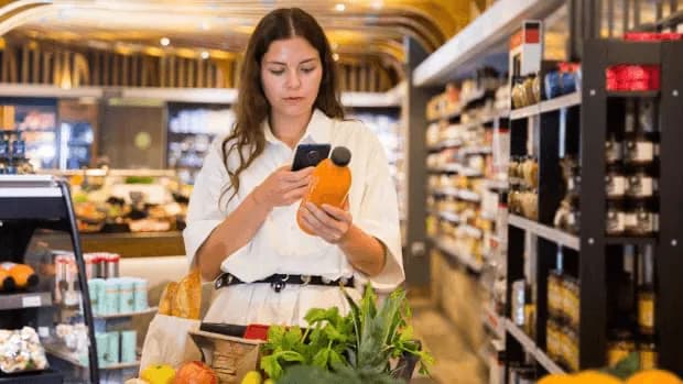 Woman scanning QR code in a supermarket